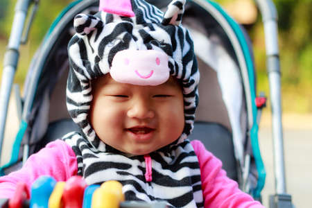Happy young baby sitting in the baby carriageの写真素材