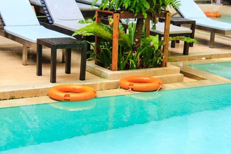 orange lifebuoy with yellow ropes on tiled floorのeditorial素材