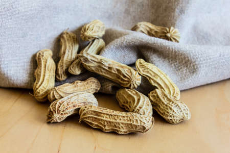 peanut on a brown fabric and wooden tableの写真素材