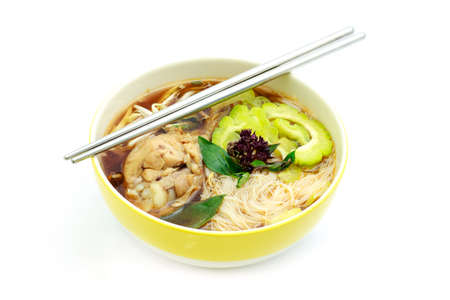 Chicken soup with noodle and vegetables on white backgroundの写真素材