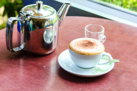 a cup of coffee on the wooden table