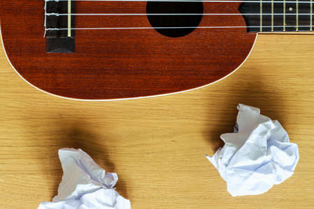 ukulele guitar with paper scraps on woodの写真素材