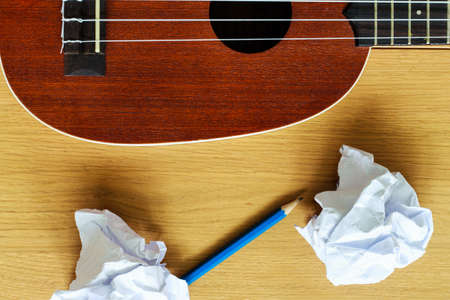 ukulele guitar with paper scraps and pencilの写真素材