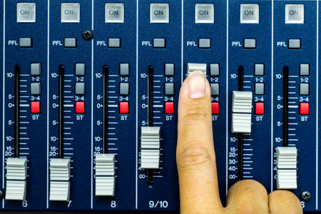Hand pushing open a fader on a sound deskの写真素材