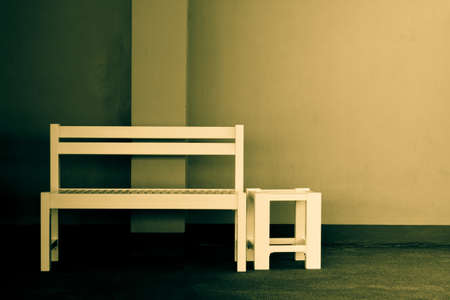 Lonely bench with white wall in the back