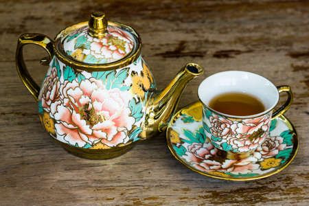 Chinaware tea pod and small drinking bowls on wooden tableの写真素材