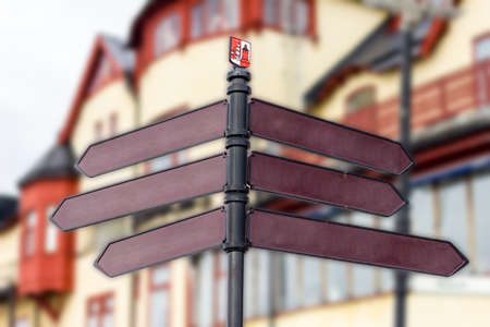 blank signs pointing many directions with old town background