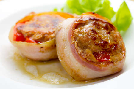 Meat medallions wrapped bacon with vegetable garnishの写真素材