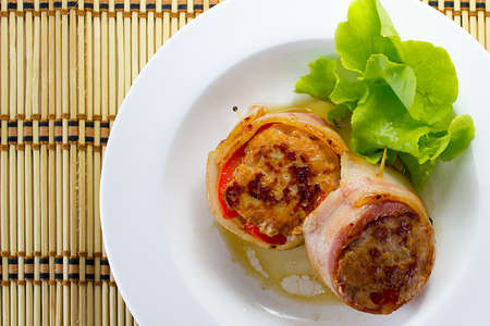 Meat medallions wrapped bacon with vegetable garnishの写真素材
