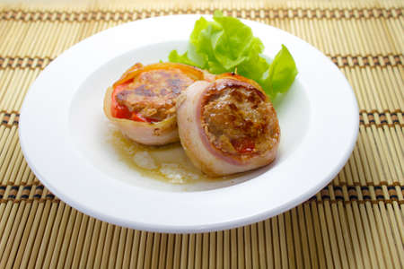 Meat medallions wrapped bacon with vegetable garnishの写真素材