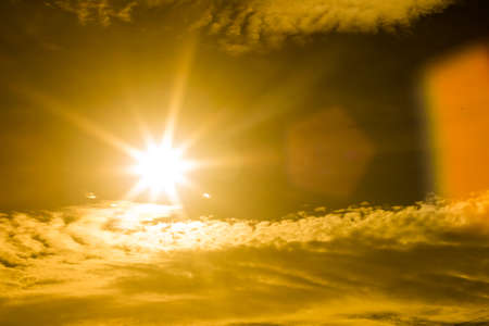 Summer background with a magnificent sun burst with lens flare. ( Hot white balance for warm feeling)の写真素材
