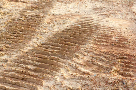 wheel track and foot print on clay roadの写真素材