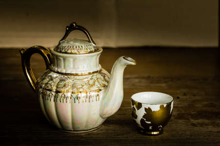 Still life with teapot on wooden table over grunge backgroundの写真素材