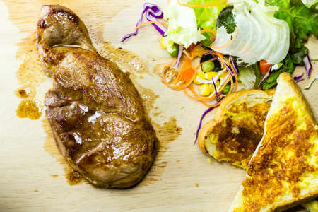Grilled steaks on wood with salad & bread