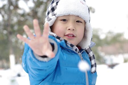 a boy is showing hand in winterの写真素材