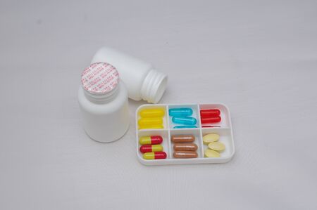 colorful capsules and pills with packaging on pure backroundの写真素材