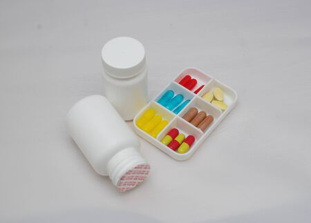 colorful capsules and pills with packaging on pure backroundの写真素材