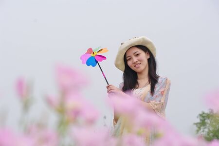 a girl in garden with pinwheel in handの写真素材