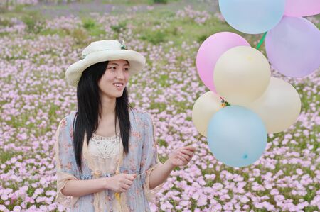 a girl is smiling with balloons in handの写真素材