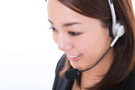 Young customer support operator with headset and smilingの写真素材
