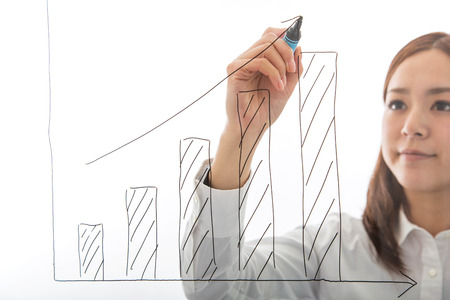 Businesswoman hand write growth graph isolated on whiteの写真素材