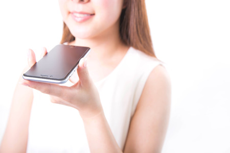 Young woman recording voice message with smartphoneの写真素材