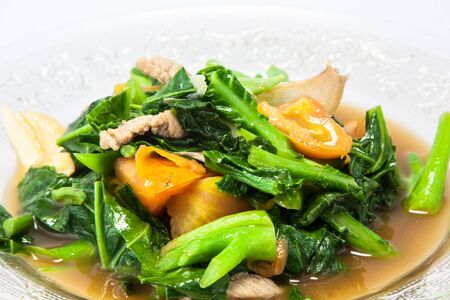 pork fried kale and tomatoes in glass dishの写真素材