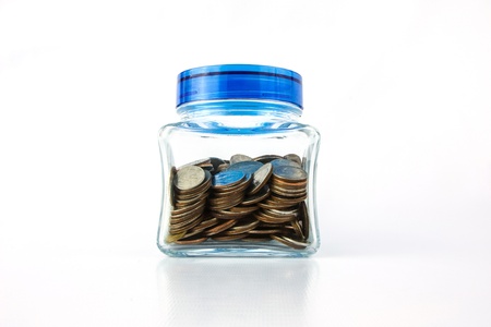 Coins in a glass bottle with blue lidの写真素材