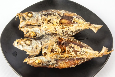 Fried Dried Mackerel on a black dishの写真素材