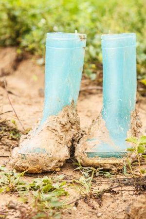 A Pair of dirty shoe on muddy groundの写真素材