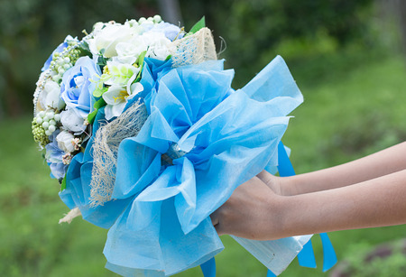 Hand giving bouquet of beautiful flower - surprise on happy dayの写真素材