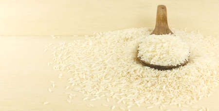 Heap of Thai jasmine rice grain on wooden backgroundの写真素材