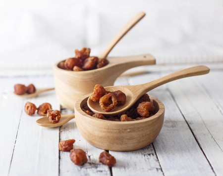 Close up of dried longan on white wooden backgroundの写真素材