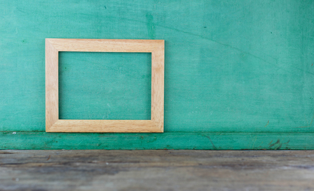 Brown square wooden frame on green backgroundの写真素材