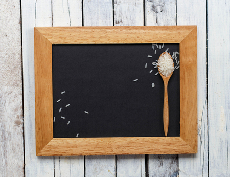 Blank black paper with wood frame and rice grainsの写真素材