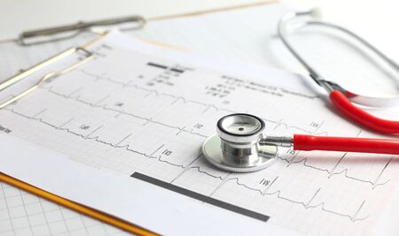 Healthcare and medical concept - Red stethoscope and clipboard