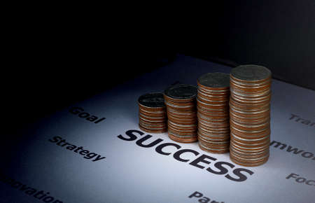 Finance and investment concept - Stack of coins on success word which surround with other factor to...