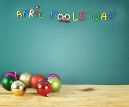 Happy April fool's day - colorful text made from crayon on green background with many party ballの写真素材