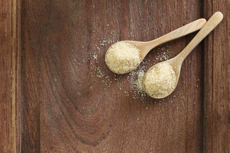 Top view two spoons of brown sweet  sugar  on wooden table with copy space.の写真素材