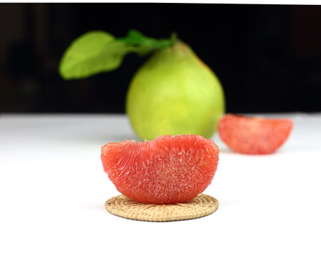 Thai sweet fruit - Piece of ripe red siam ruby pomelo , pummelo, grapefruit with no peel on against group of fruits.の写真素材