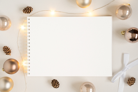 Elegant blank paper stationery photo based mockup. Horizontal landscape festive presentation for art design. Minimalist stylish text template. Flat lay of notepad, Christmas lights, gold garlandの写真素材