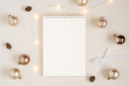 Elegant blank paper stationery photo based mockup. Vertical festive presentation for art design. Minimalist stylish banner, text template. Flat lay of notepad, Christmas lights, gold ornaments.の写真素材