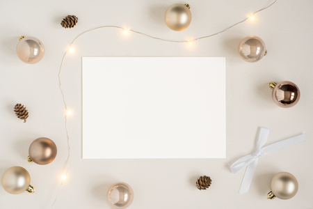 Elegant blank paper stationery photo based mockup. High resolution festive presentation for art design. Minimalist stylish banner, text template. Flat lay of card, Christmas lights, golden ornaments.の写真素材