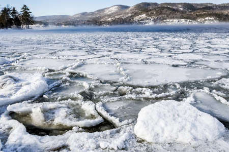Ice formation on the lake with mountain in Adirondack