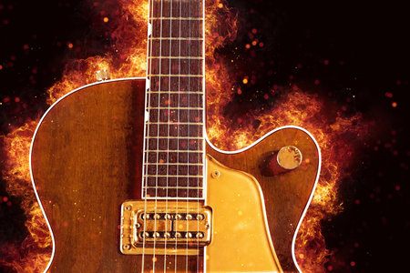 Electric guitar in the flames on a dark background. Guitar in the fire