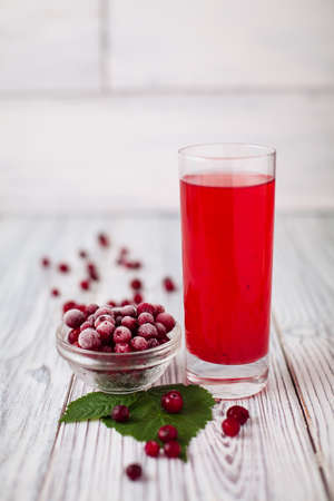 Cranberry juice glass red, hoarfrost wooden leavesの写真素材