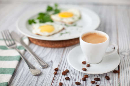 fried eggs coffe green fork knife woodenの写真素材