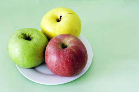 three apples in the plateの写真素材