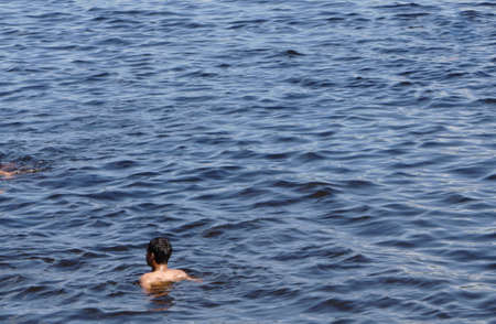 the guy standing breast-deep in dark waterの写真素材