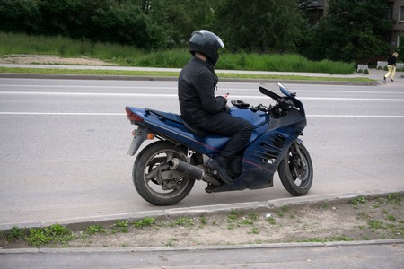 Motorcyclist riding on his motorcycle at sunsetの写真素材